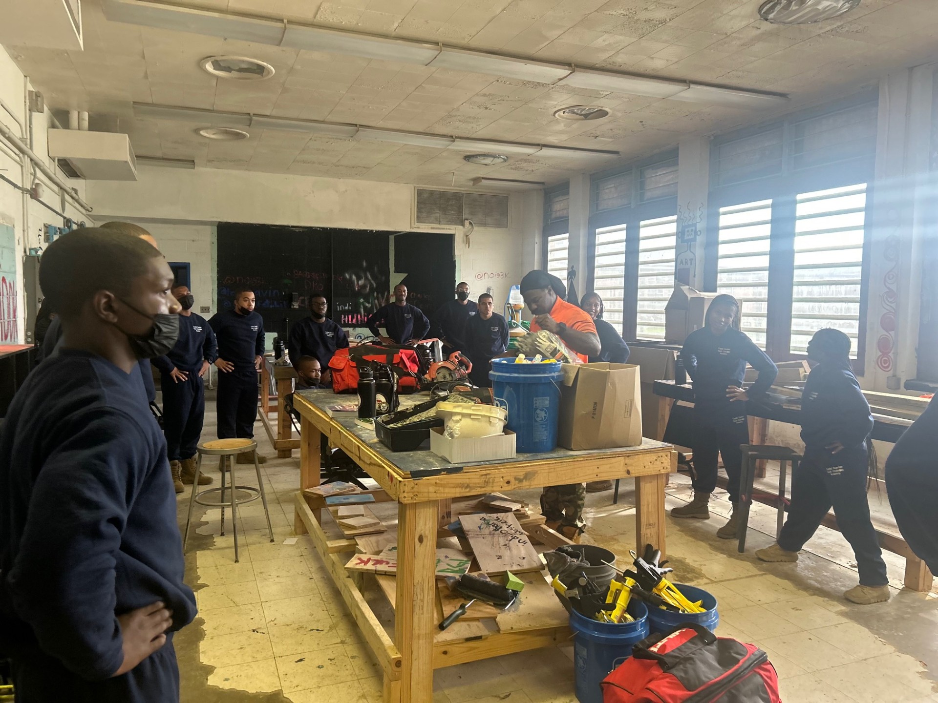Full training cohort gathered in a workshop around tools and materials