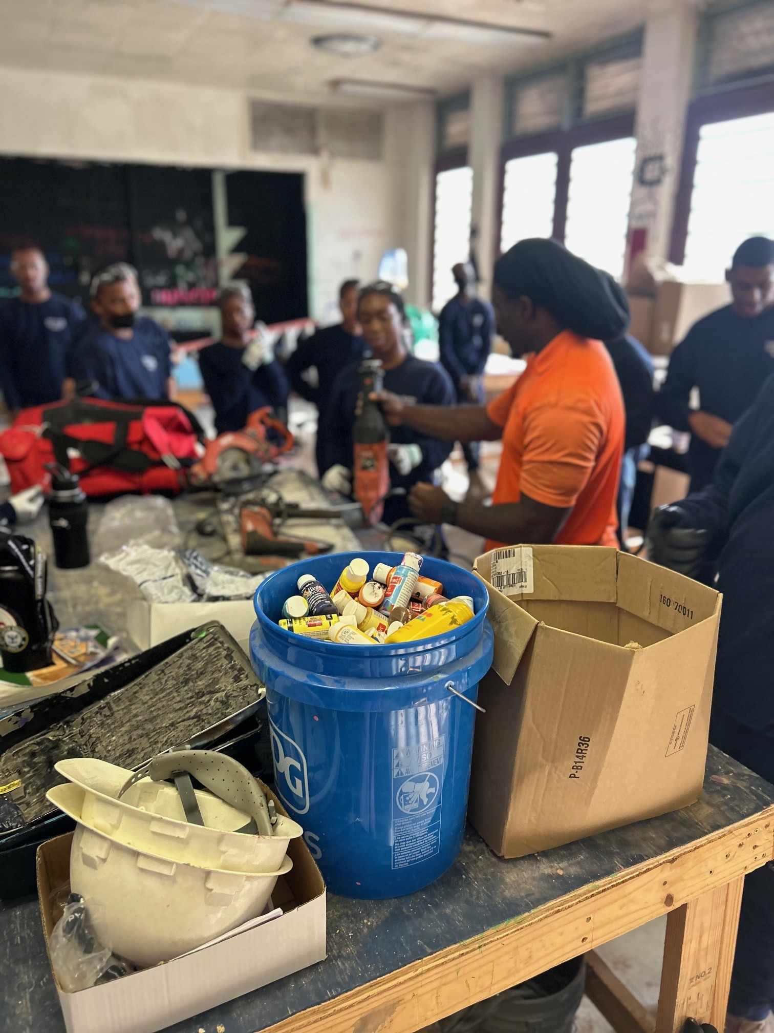 Instructor demonstrating safety equipment and tools in a training workshop