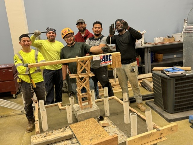 A group of trades trainees standing together after a hands-on build exercise
